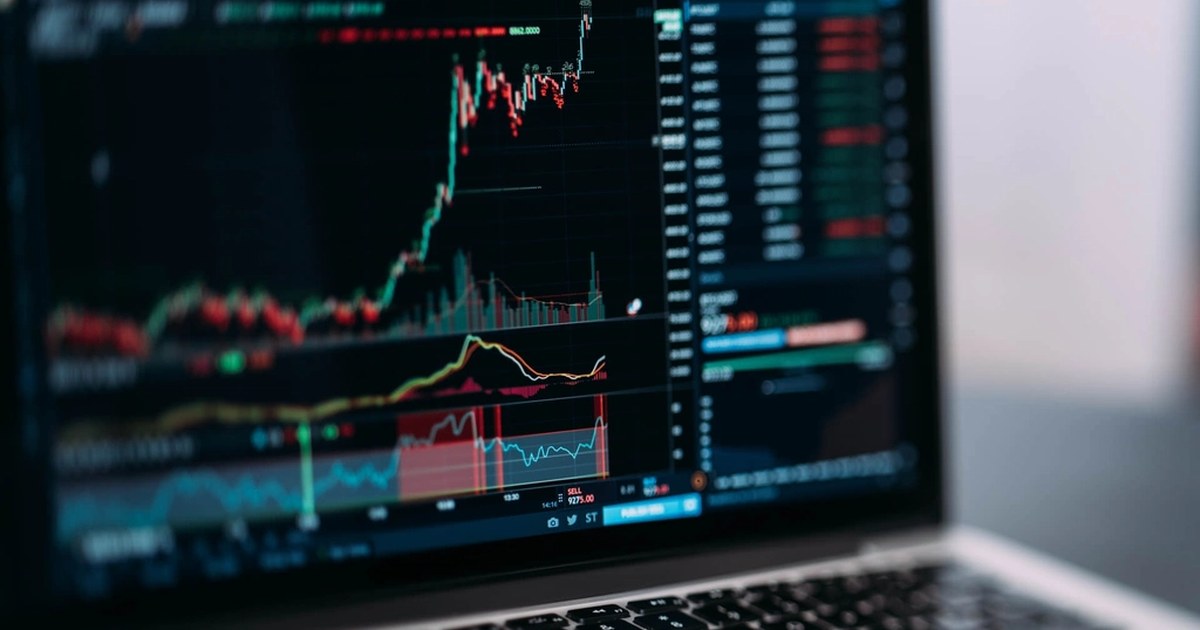 Funding Rate: ein Laptop mit dem Kerzenchart eines Krypto Perpetual Kontrakts und Marktindikatoren daneben