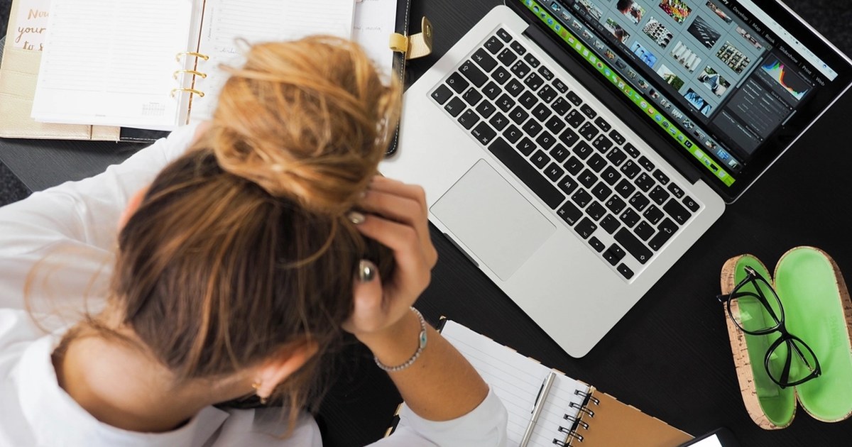 Una persona con las manos en el pelo delante de un portátil: la psicología del trading es lo que pasa en la cabeza cuando una posición sale mal