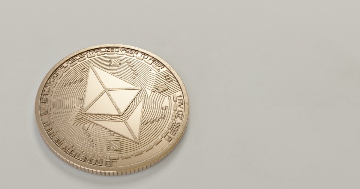 A gold crypto coin resting on a light surface
