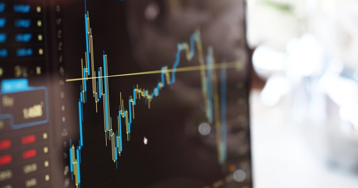 Un grafico a candele su uno schermo con una linea gialla orizzontale: il trailing stop è uno stop che segue il prezzo quando si muove nella direzione giusta